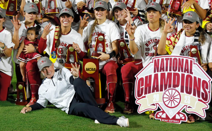 Oklahoma coach Patty Gasso players hold up three fingers after winning their third consecutive Women's College World Series title.
